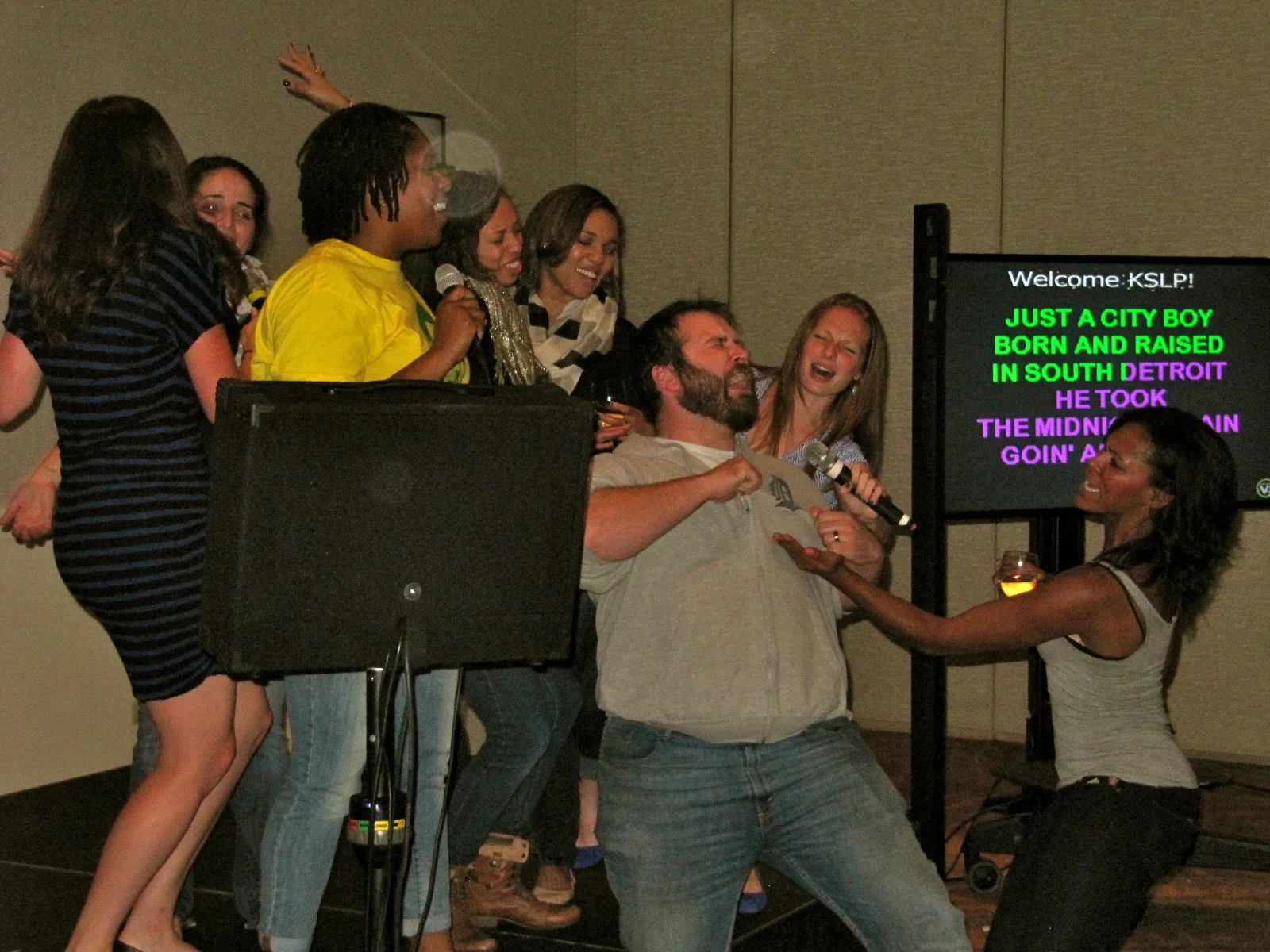 Karaoke screen showing song lyrics during a live event in NYC